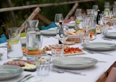 A lomg table is covered in food and drink at camping Le Farfalle - Le Marche